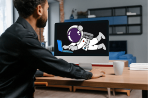 Man working on his computer with an astronaut showing on his screen
