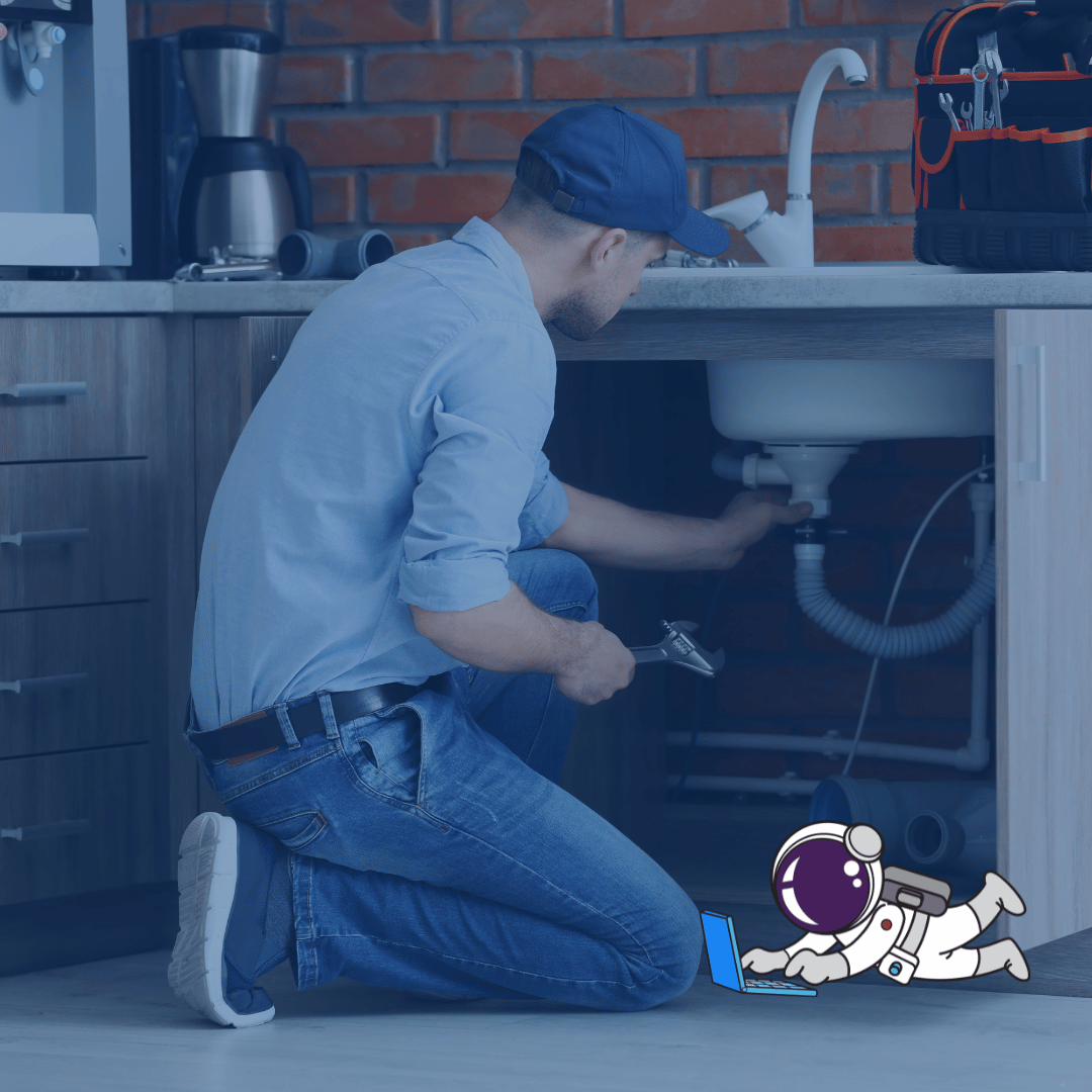 A man repairing a sink in a kitchen.